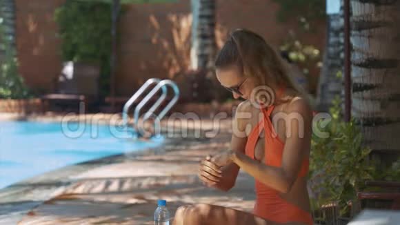 比基尼的女人用防晒霜代替游泳池视频的预览图