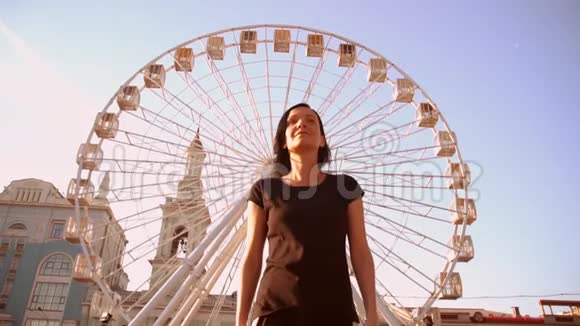 背景中带摩天轮行走的女性的正面景色视频的预览图