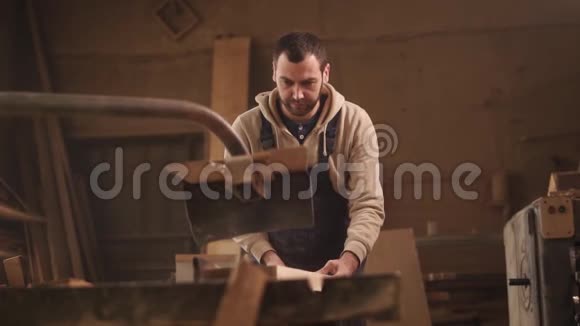 前面把锯木头的镜头放在圆机上穿工作服的木匠视频的预览图