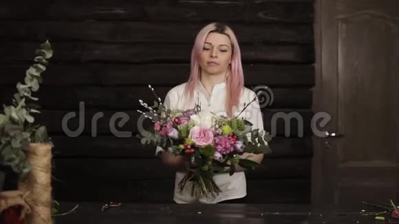 迷人的女孩花店展示了她的作品在长而稳定的茎上放了一束美丽的五颜六色的花视频的预览图