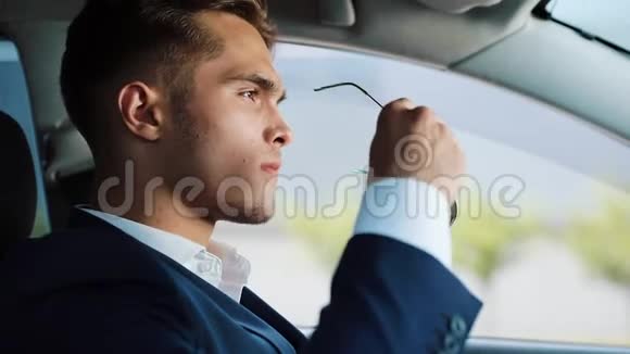 年轻的商人坐在车里时戴着太阳镜他坐在方向盘后面成功概念职业视频的预览图