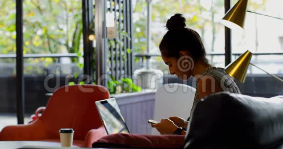 年轻的高加索女性高管在笔记本电脑上工作在现代办公室里喝咖啡视频的预览图