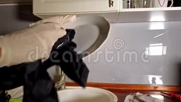 女人用手套在厨房里烘干盘子视频的预览图