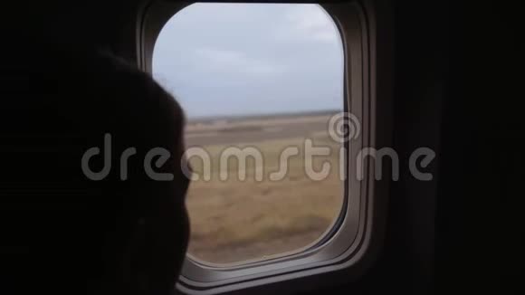 一个年轻的女孩看着飞机的窗户飞机降落了4k视频的预览图