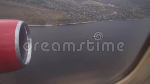 从带有发动机的飞机机翼上的窗口观看飞机飞过河面从窗口查看4k视频的预览图