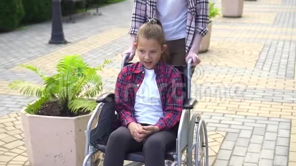 女孩带着一个残疾的少年坐轮椅慢节奏视频的预览图