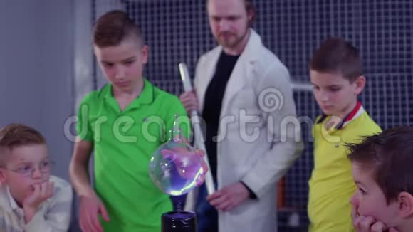 男孩在特斯拉线圈和玻璃球上做实验视频的预览图