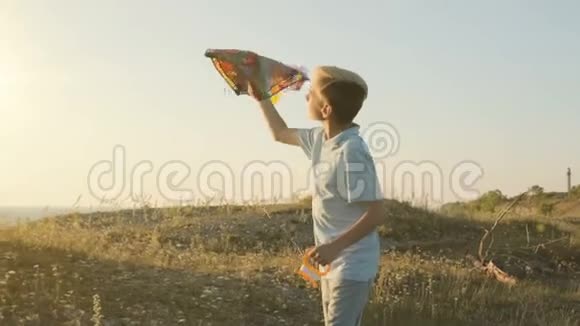 男孩奔跑着试图在大风中在天空中发射风筝视频的预览图