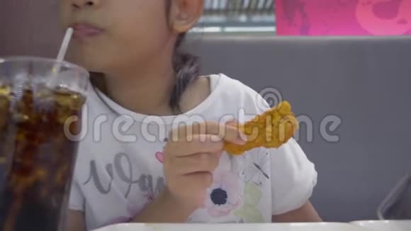 亚洲可爱的女孩吃食物而使用手机在午餐视频的预览图