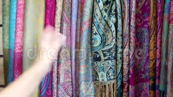 妇女购物检查纺织品中央广场市场摊档摩洛哥马拉喀什视频的预览图