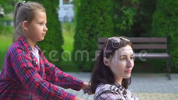 母亲在轮椅上致残女儿在公园里散步视频的预览图