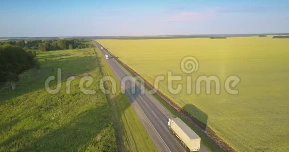 在田野和树林之间开着卡车的高速公路视频的预览图
