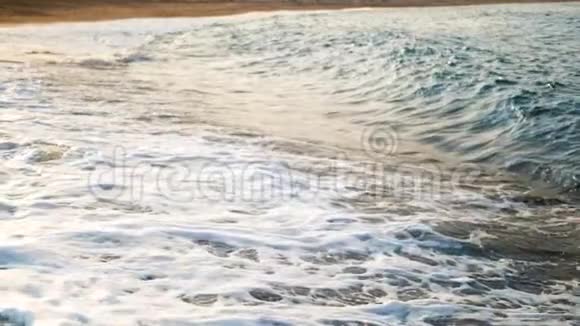 拍摄日落时海浪拍打海岸后海水旋转和沸腾的慢动作视频视频的预览图