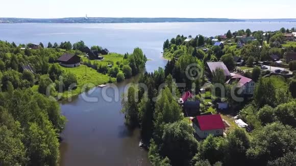 令人叹为观止的鸟瞰森林海岸与小别墅在夏季阳光明媚的一天剪辑沿海地区视频的预览图