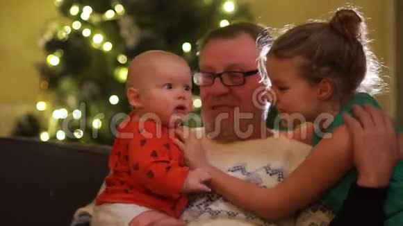 快乐的祖父拥抱他的孙子孩子和女孩花时间和他们的祖父退休圣诞前夜视频的预览图