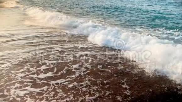 拍摄日落时海浪拍打海岸后海水旋转和沸腾的慢动作视频视频的预览图