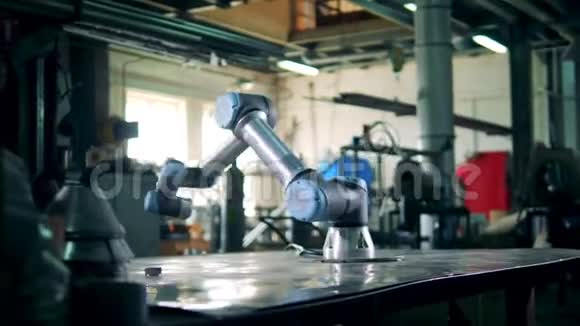 一个机器人在工厂的桌子上用齿轮工作视频的预览图