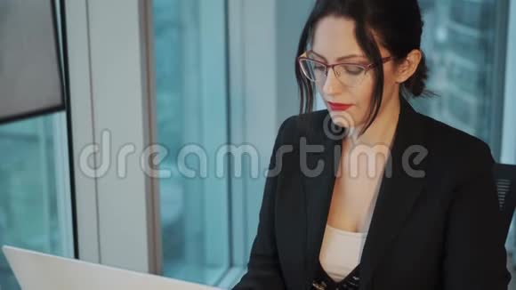 一位年轻商务女性在现代办公室电脑工作的特写照片视频的预览图
