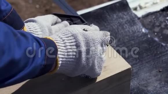 为一个戴着防护手套的木匠在木板上写东西的手关上剪辑细木厂视频的预览图