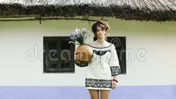 一个乌克兰女孩站在乌克兰小屋附近视频的预览图