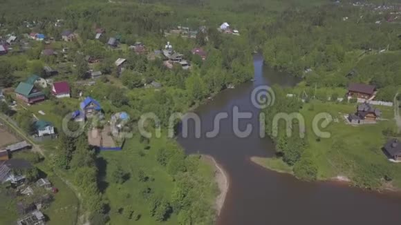 在温暖的针叶树和落叶树包围的大河附近的平房村和房屋的鸟瞰图视频的预览图