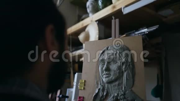 雕塑家的特写镜头在艺术工作室画布上创作女性面部雕塑视频的预览图
