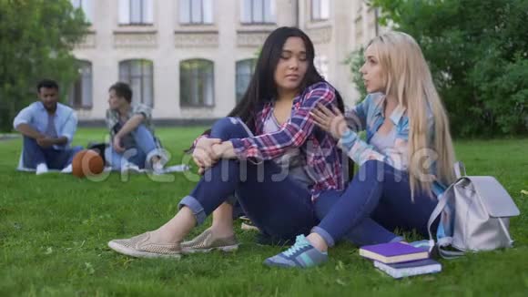 最好的女性朋友坐在草地上讨论青少年问题支持视频的预览图