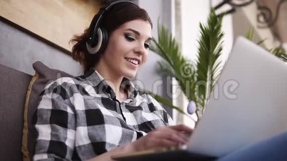 特写一段美丽的穿格子衬衫的黑发女孩的镜头快乐的女孩和一个用笔记本电脑聊天的人视频的预览图