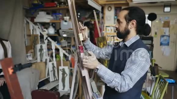 熟练的雕塑家在画布上用橡皮泥创作女性在艺术工作室摆模特的脸视频的预览图