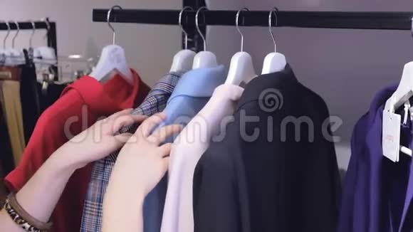 女人的手在店里的货架上整理衣服视频的预览图