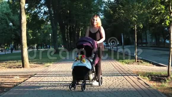 妈妈带着孩子躺在婴儿车里散步城市景观视频的预览图