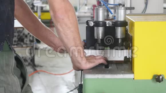 生产PVC窗男子在切割机上安装PVC型材并将其切割以适应进一步的装配视频的预览图