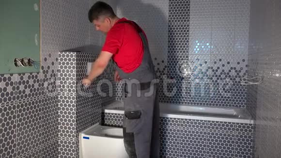 熟练工人安装新的现代浴室马桶冲水按钮视频的预览图