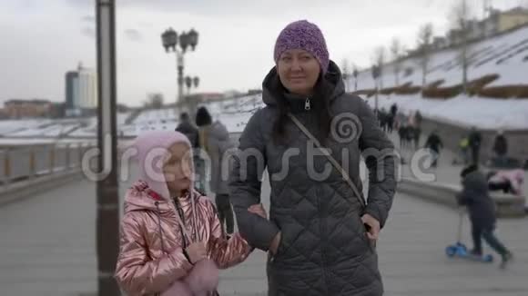 小女儿说话和妈妈牵手走在码头上视频的预览图