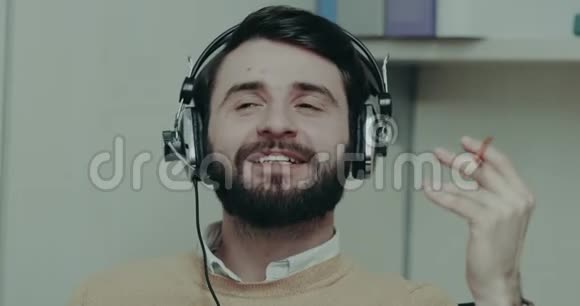 男子呼叫中心操作员使用耳机与客户交谈并玩笔视频的预览图