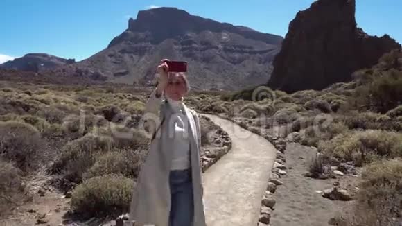 女孩走在Teid火山附近的电话视频的预览图