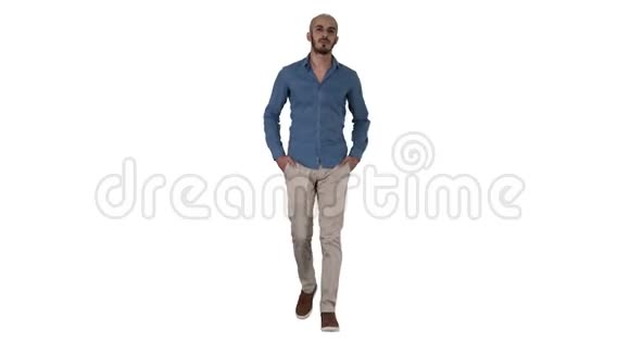 英俊的阿拉伯年轻人穿着休闲装走路双手放在白色背景上的口袋里视频的预览图