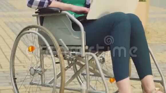 一个年轻漂亮的女商人穿着轮椅的衬衫在笔记本电脑上打字视频的预览图