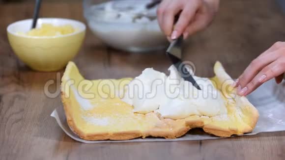 在家里做瑞士卷的时候要把无法辨认的糖果摊铺奶油贴在海绵蛋糕上视频的预览图