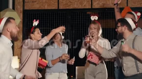 一群年轻的朋友正在庆祝圣诞节用酒精敲打玻璃视频的预览图