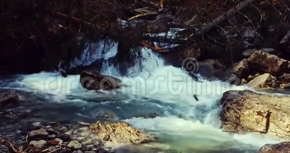 一条河在春天阿尔卑斯山山脉的美丽景色中流过岩石垂直4k视频的预览图