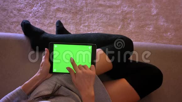 用绿色屏幕的平板电脑特写性感女性的肖像女孩双腿舒适穿着袜子视频的预览图