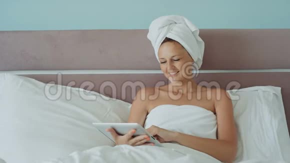女士使用平板电脑在酒店房间微笑视频的预览图