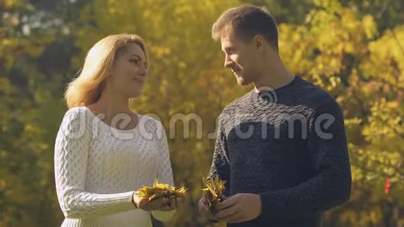 年轻的一对夫妇吐着秋叶快乐的时光浪漫的约会视频的预览图