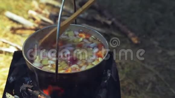 一个木勺用食物搅拌食物是用保龄球帽煮熟的视频的预览图