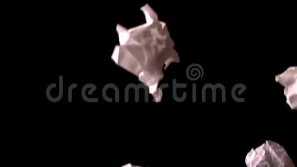 皱巴巴的纸落在黑色的背景上视频的预览图