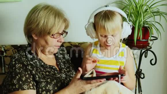 奶奶和孙女在一起玩得很开心用平板电脑视频的预览图