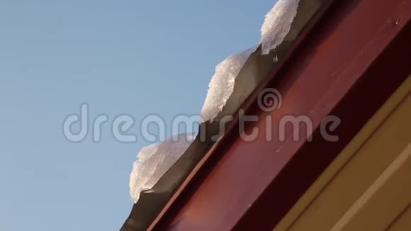 融化的冰柱从屋顶上滴落下来春滴冰柱融化了太阳和雪视频的预览图