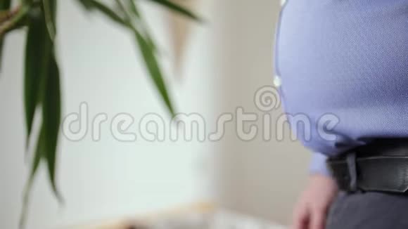 穿衬衫的胖子抚摸着他的肚子视频的预览图