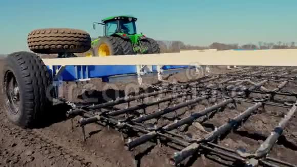 用大轮犁把农业耕作拖拉机合上在肥沃的农田上耙土耕种视频的预览图
